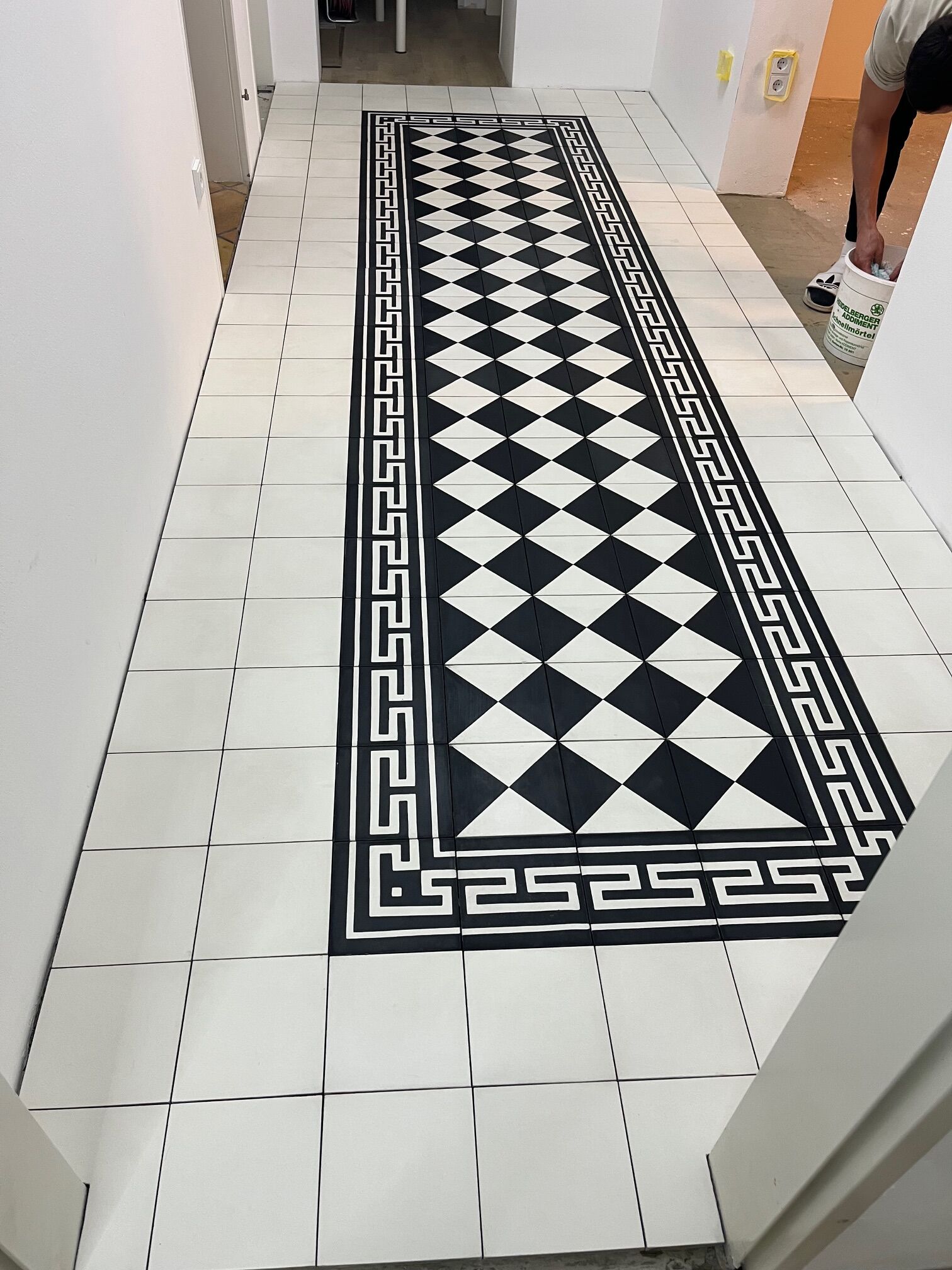 Schwarz weiße Zementfliesen im Flur mit Bordüre Schwarz weiße Zementfliesen im Flur mit geometrischem Muster und Bordüre